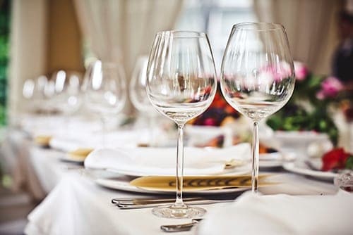 wedding-catering-sevierville-tn Tables set up for wedding with wine glasses and flower arrangements